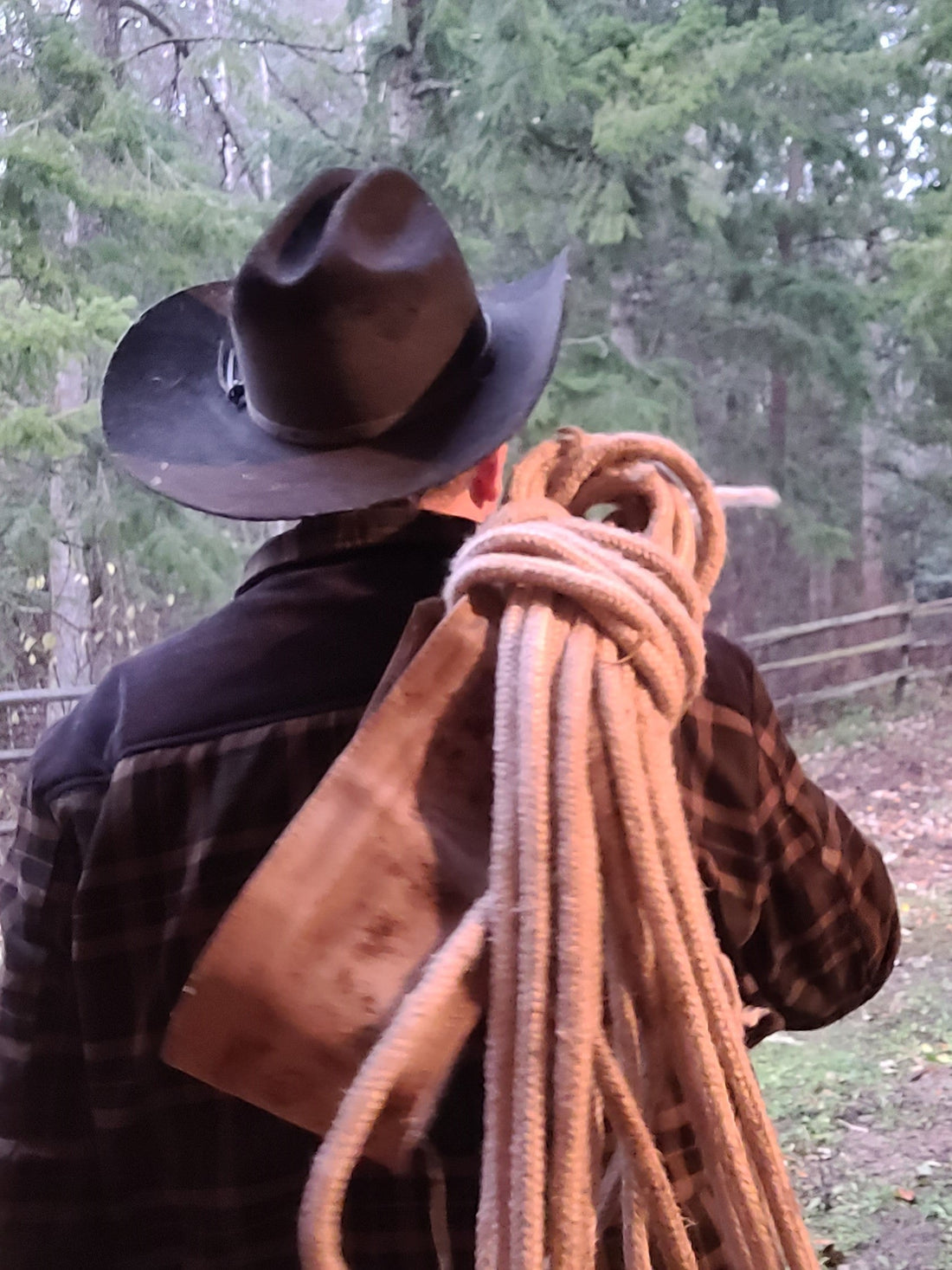 a horse packer carrying a lash rope over his shoulder